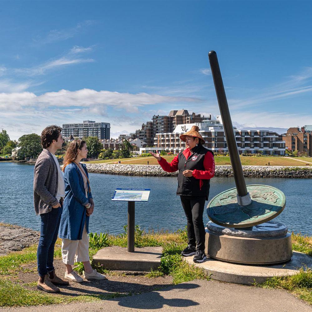 A couple learns about local Indigenous culture at one of the Seven Signs of the Lekwungen in Victoria, BC.