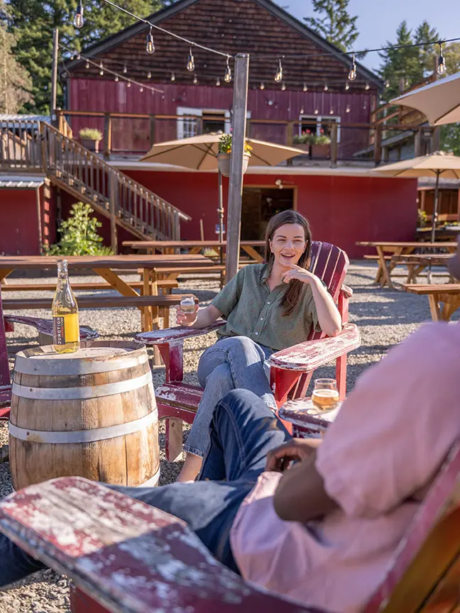 A young couple sips cider on the patio at Junction Orchard & Cidery in Victoria, BC