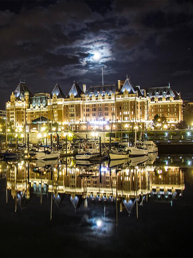 A full moon rises above the Fairmont Empress at night in Victoria, BC