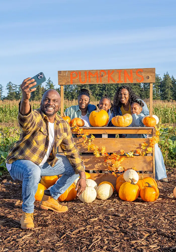 A family takes a selfie photography at the Pumpkin Patch at Ocean View Estates in Victoria, BC
