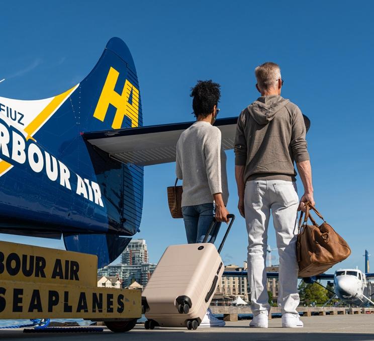 A couple disembarks a Harbour Air Seaplanes flight on a dock in Victoria's Inner Harbour