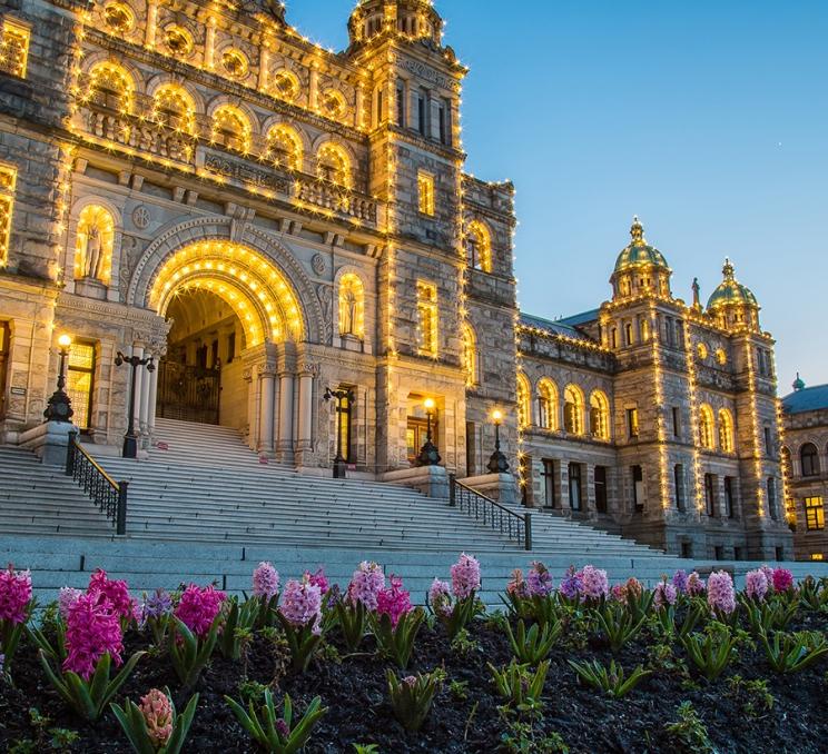 The BC Parliament Buildings illuminated at sunset in Victoria, BC