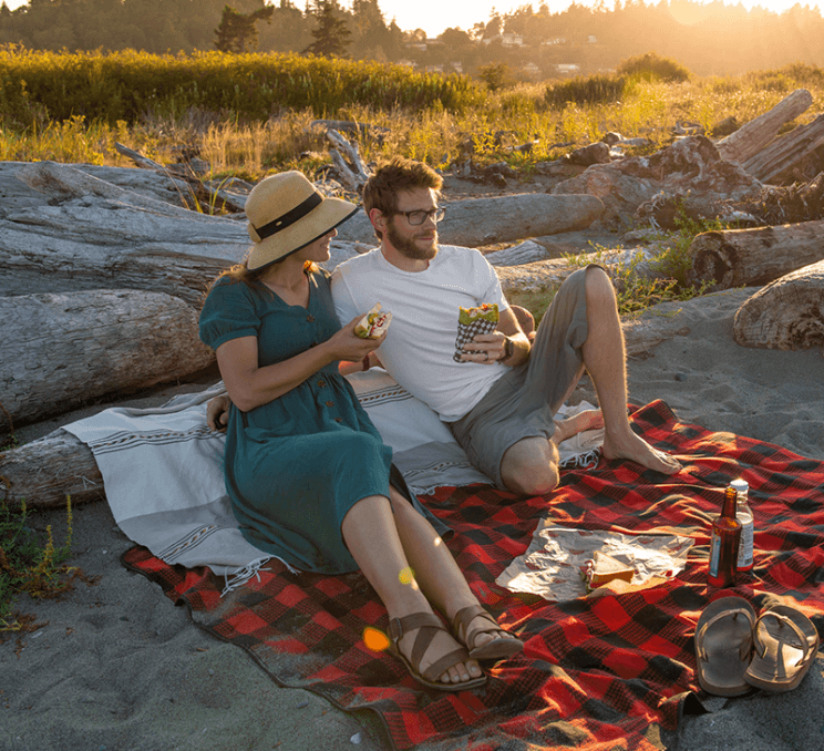 A couple enjoys a picnic on a beach in Victoria, BC