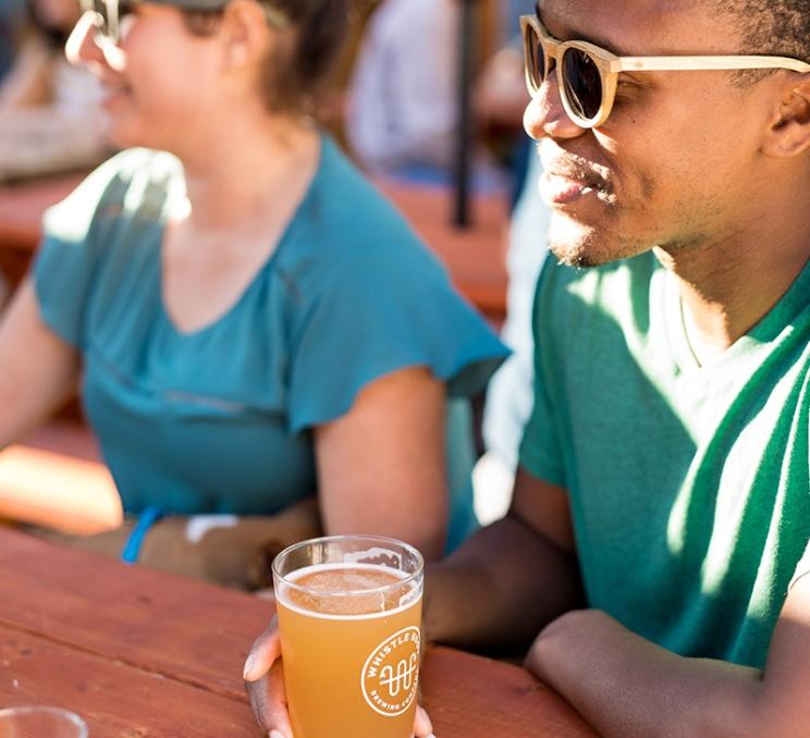 Friends enjoy a pint on the patio at Whistle Buoy Brewing in Victoria, BC