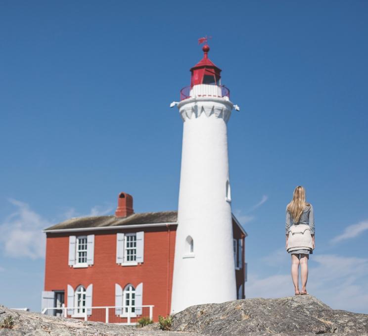 A woman enjoys the view of Fisgard Lighthouse in Victoria, BC