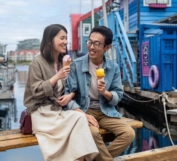 A young couple enjoys ice cream on Fisherman's Wharf in Victoria, BC