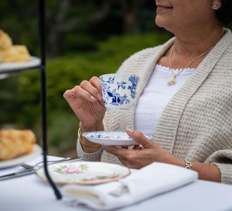 A woman enjoys afternoon tea at the Teahouse at Abkhazi Garden in Victoria, BC