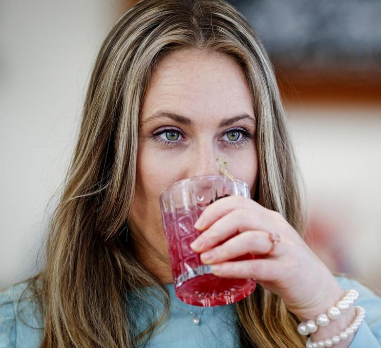 A woman enjoys a cocktail at 10 Acres Bistro in Victoria, BC