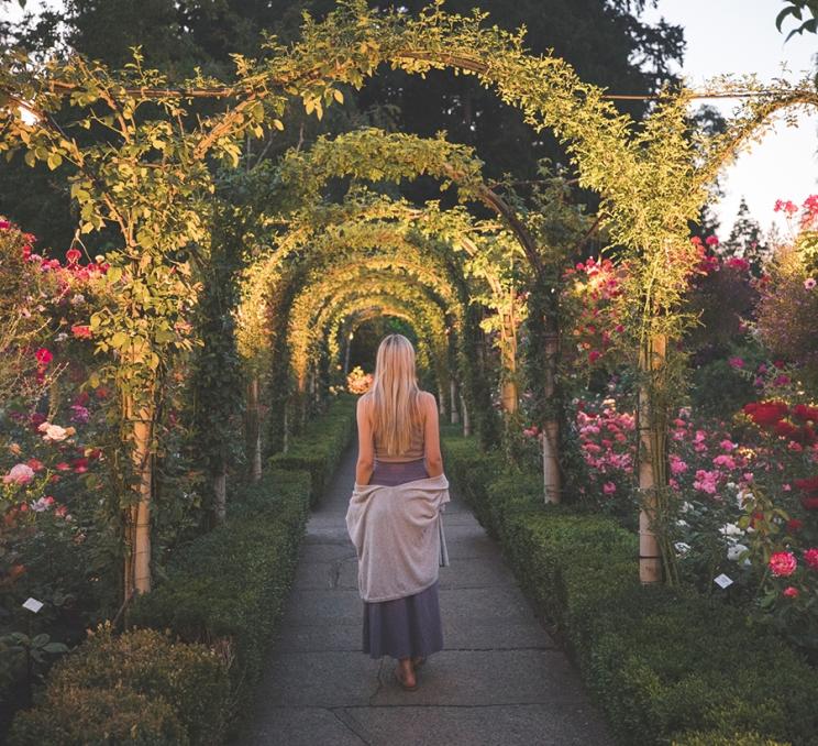 A woman walks along a pathway at The Butchart Gardens in Victoria, BC