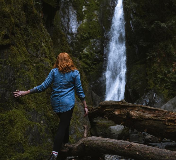 A woman walks toward Niagara Falls in Goldstream Provincial Park in Victoria, BC