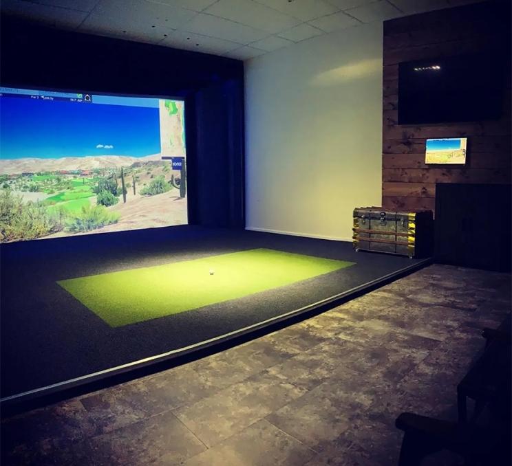 The interior of a booth at Iron and Wood Golf Simulators in Victoria, BC