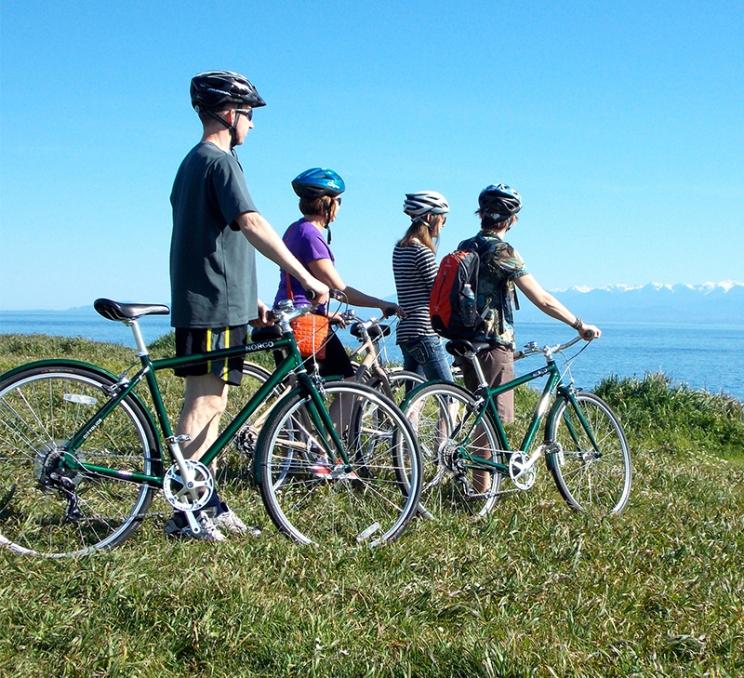 A group of cyclists enjoy the views along Dallas Road in Victoria, BC