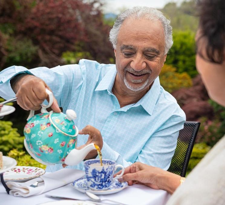 A man pours afternoon tea at the Abkhazi Garden in Victoria, BC