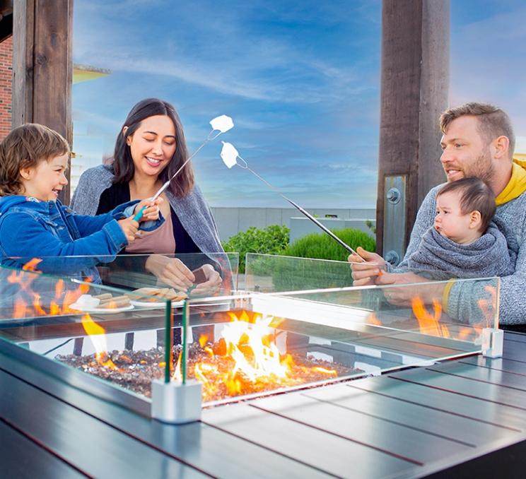 A family roasts marshmallows around a fire at Parkside Hotel & Spa in Victoria, BC