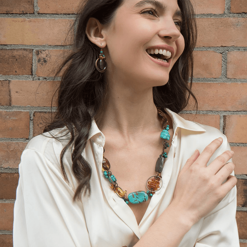 A Model in a White Shirt Showcases a Colourful Necklace from Artina's Jewellery