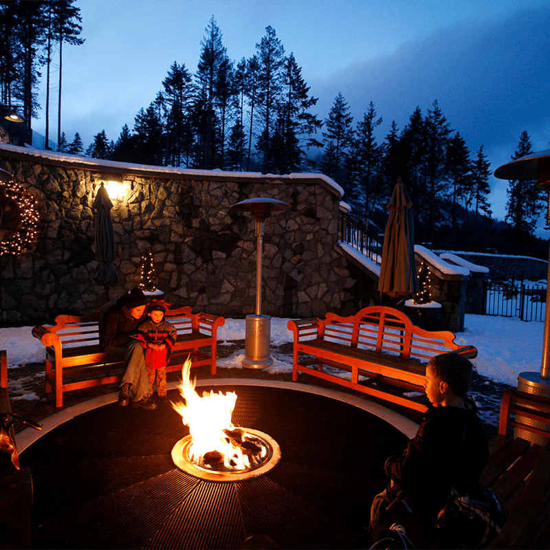 People enjoy an outdoor fire at the Westin Bear Mountain Golf Resort & Spa in the winter