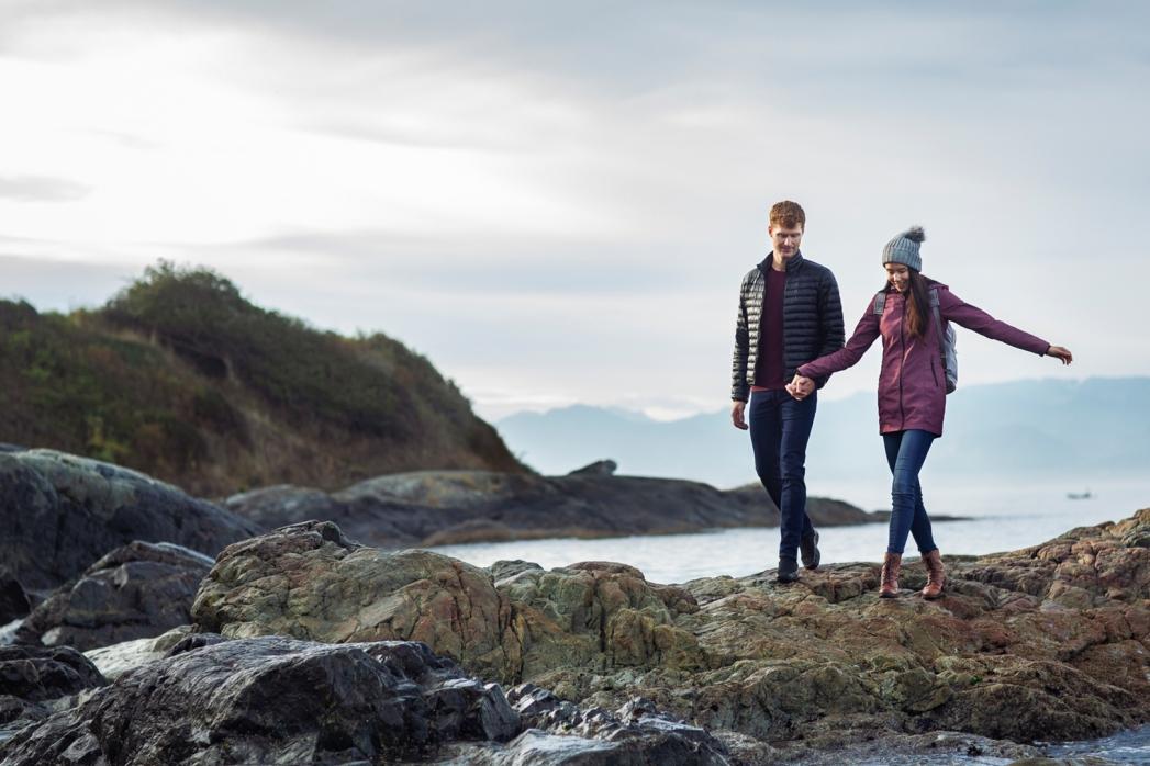 A young couple explores the beach along Dallas Road in the wintertime in Victoria, BC