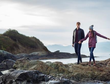 A young couple explores the beach along Dallas Road in the wintertime in Victoria, BC