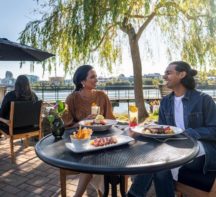 A couple dines on Glo Restaurant + Bar's waterfront patio in Victoria, BC