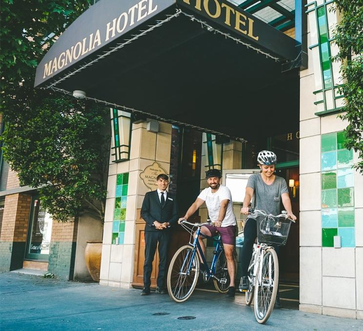 A couple departs the Magnolia Hotel & Spa on bikes in Victoria, BC