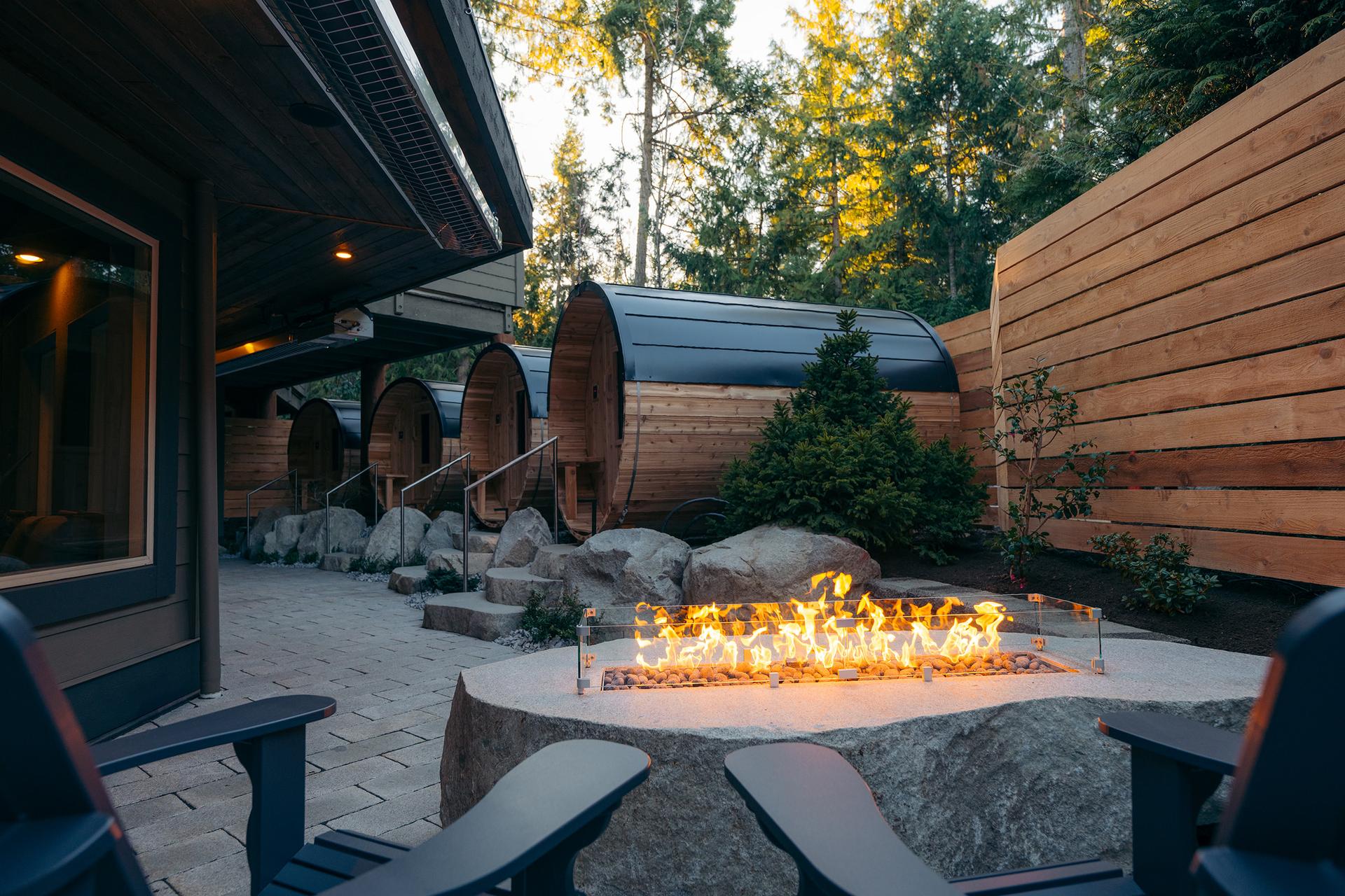 Grotto Spa 4 cedar barrel saunas on the garden patio with fire table.