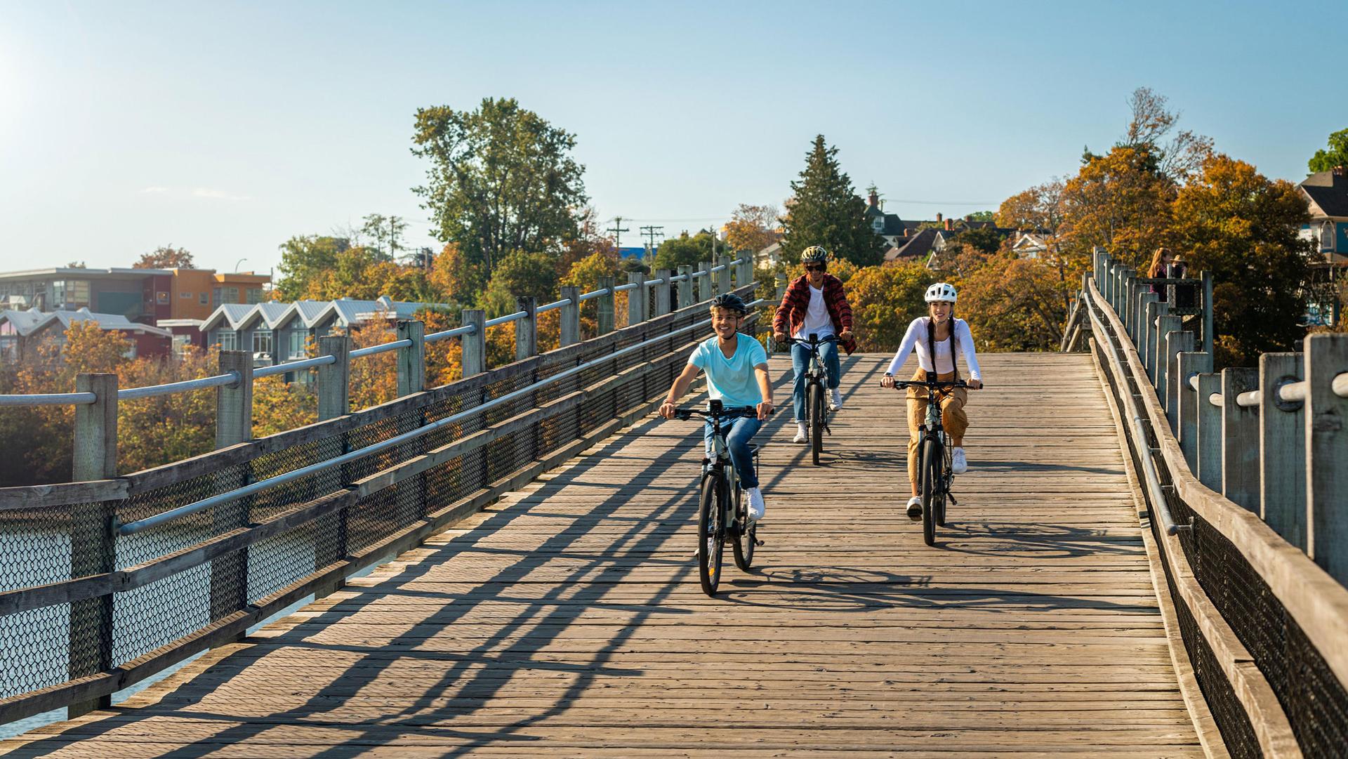 A group of friends cycles across the Selkirk Trestle in Victoria, BC