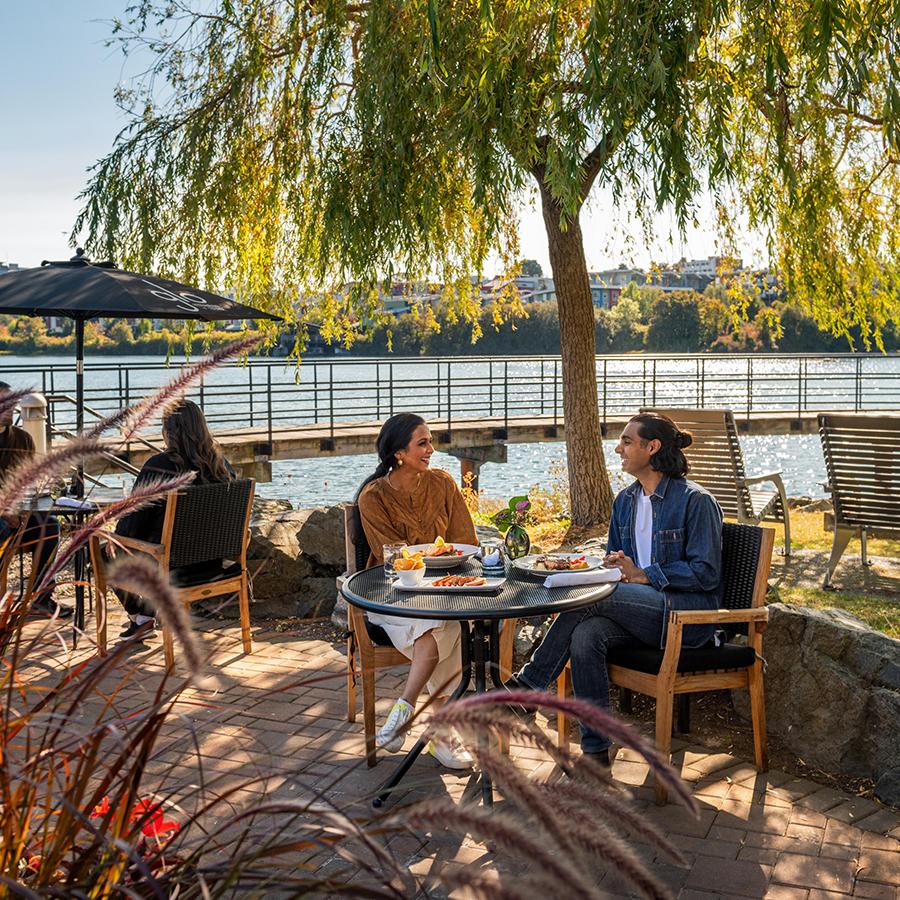 A couple dines on the patio at Glo Restaurant + Lounge in Victoria, BC