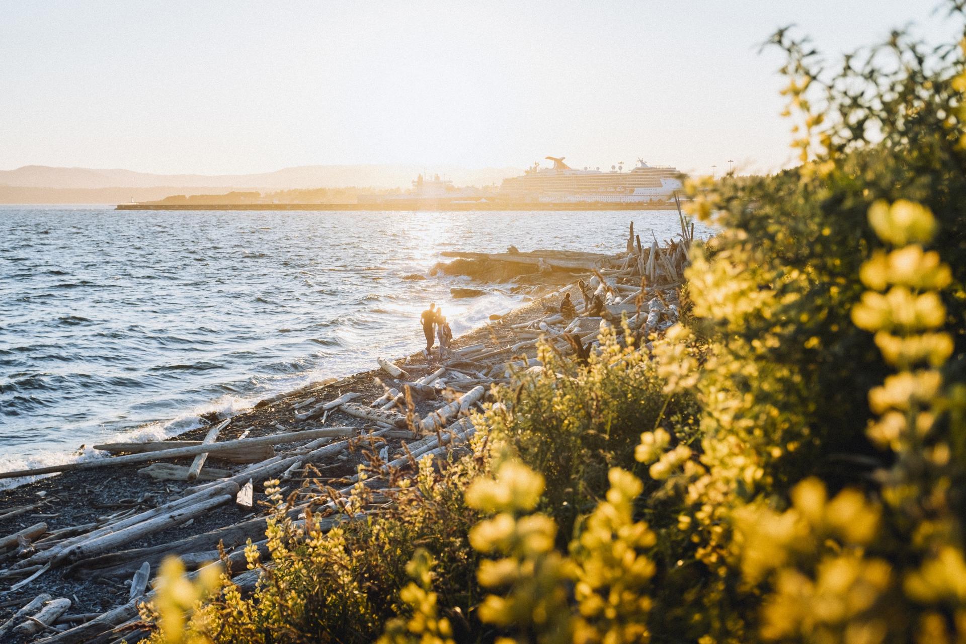 A couple walks a beach in Victoria, B.C.