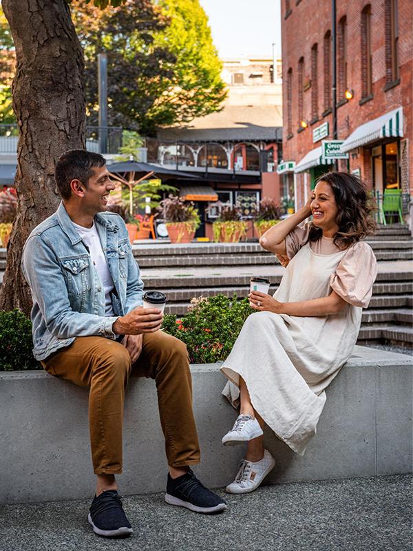 A couple locals share a coffee in Market Square, Victoria, BC