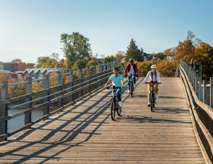 A group of friends ride bikes across the Selkirk Trestle in Victoria, BC