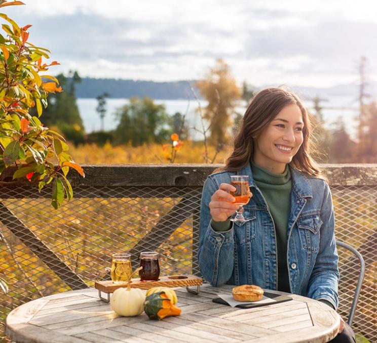 A woman enjoys a flight of cider at Sea Cider Farm & Ciderhouse in Victoria, BC