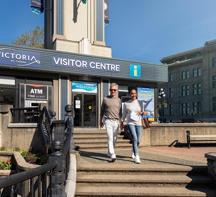 A couple walks near the Victoria Visitor Centre in Victoria, BC