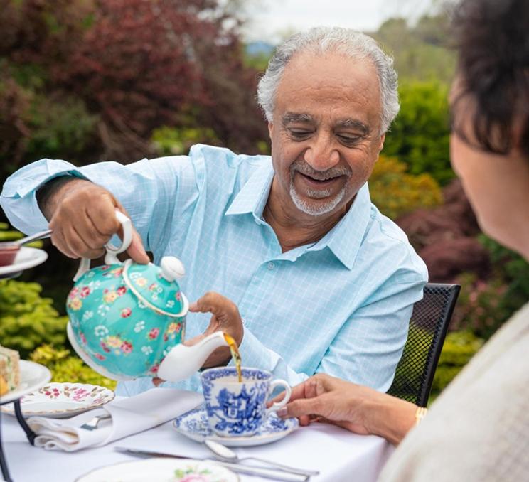 A man pours a cup of tea at The Teahouse at Abkhazi Garden in Victoria, BC