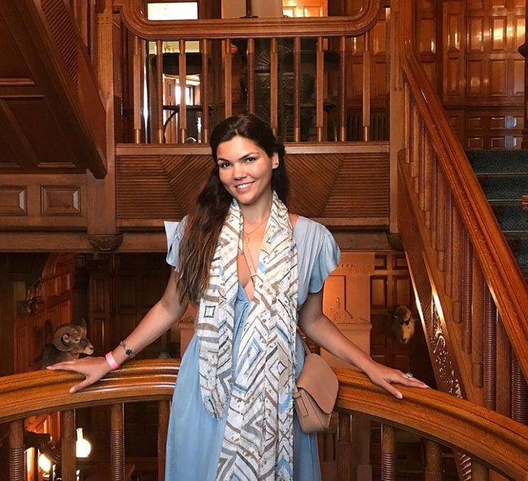 A woman poses for a photo inside Craigdarroch Castle in Victoria, BC