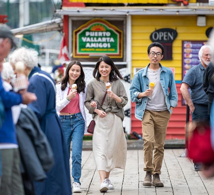 A family enjoys a walk with ice cream at Fisherman's Wharf in Victoria, BC