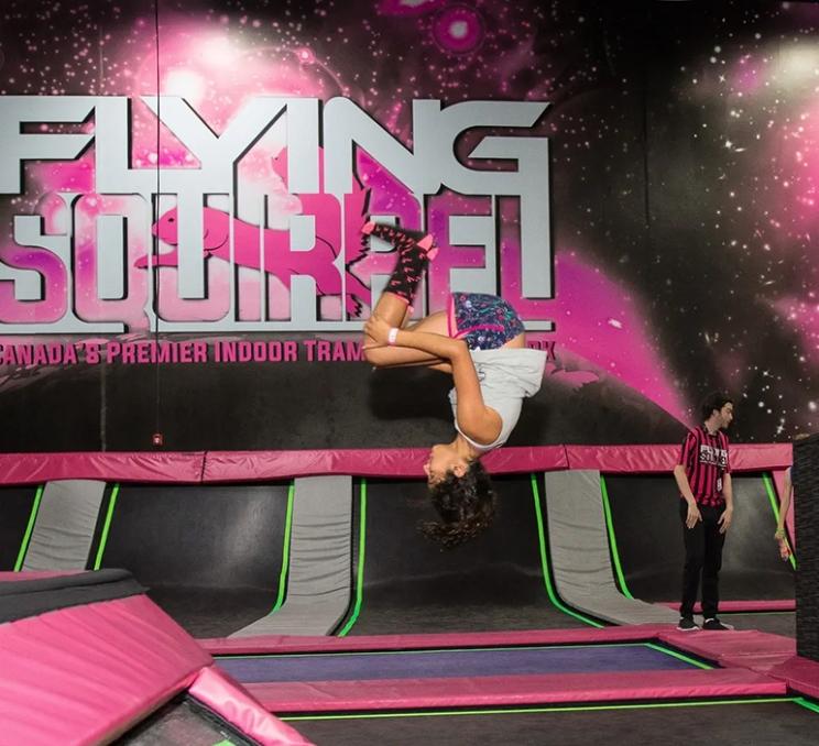 A girl does a flip on a trampoline at Flying Squirrel in Victoria, BC