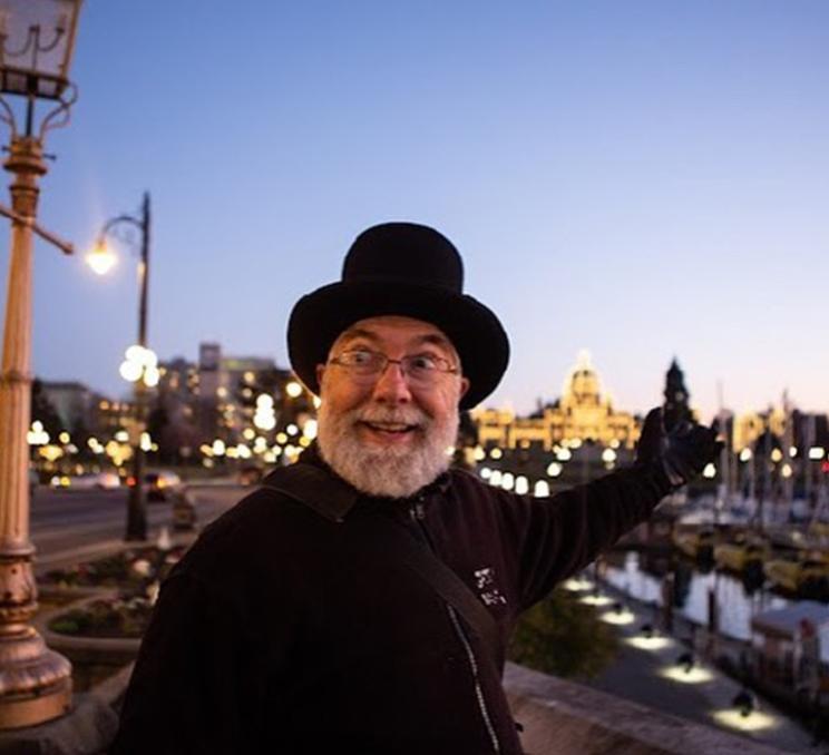 A Ghostly Walks tour guide explores Victoria, BC's Inner Harbour