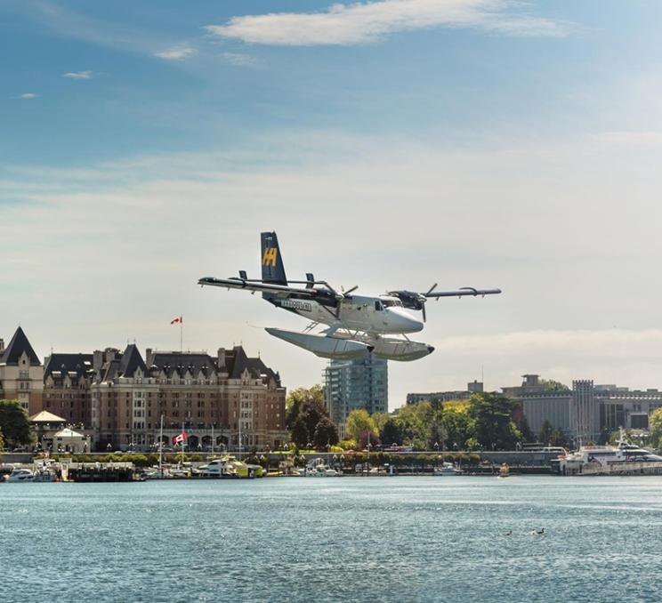 A Harbour Air Seaplanes seaplane lands in Victoria, BC's Inner Harbour