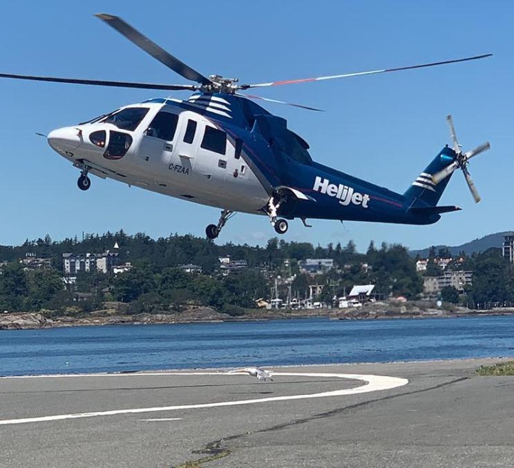 A Helijet helicopter lands at a heliport in Victoria, BC's Inner Harbour