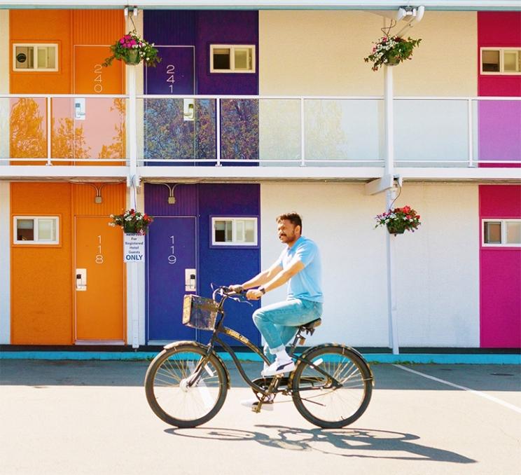 A man rides a bike in the parking lot of Hotel Zed in Victoria, BC