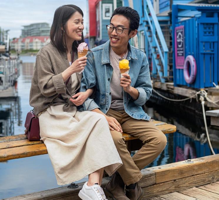 A couple enjoys ice cream on the dock at Fisherman's Wharf in Victoria, BC