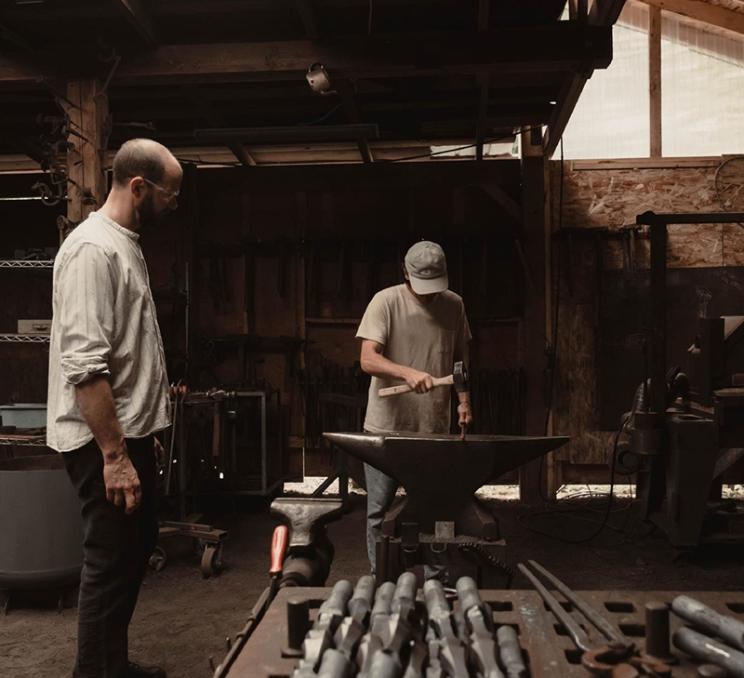 A person hammers metal at Jake James Blacksmith in Victoria, BC