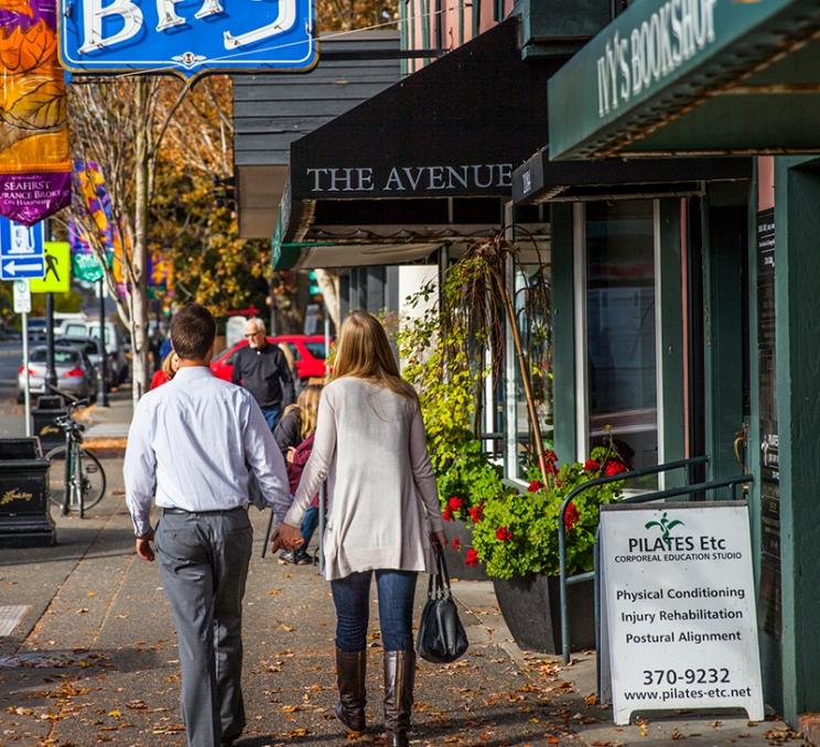 A couple walks hand-in-hand through the heart of Oak Bay in Victoria, BC