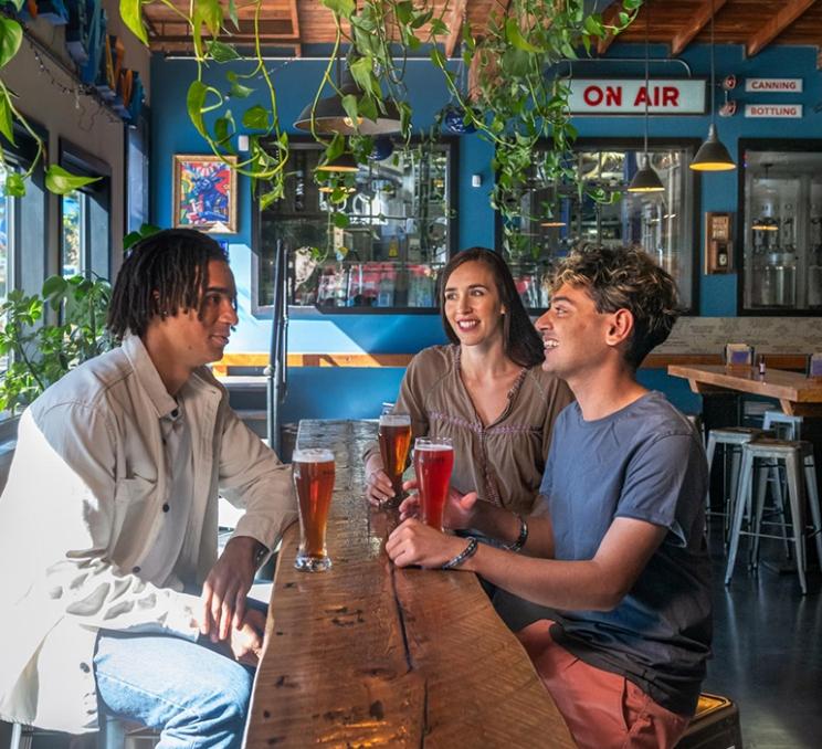 Three friends enjoy a beer at Phillips Brewing & Malting Co. in Victoria, BC