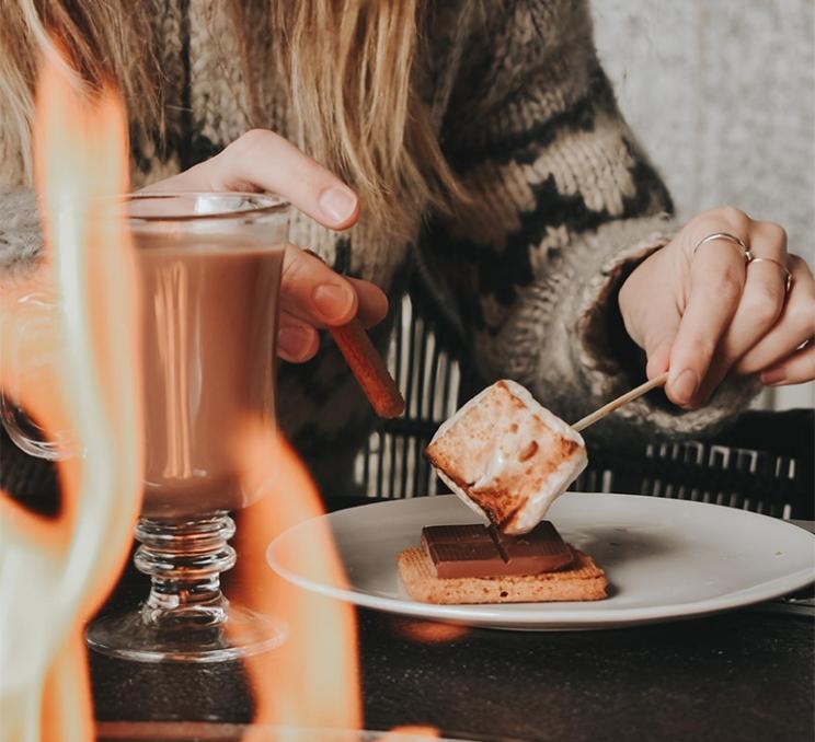 A woman makes s'mores on the Veranda at the Fairmont Empress in Victoria, BC