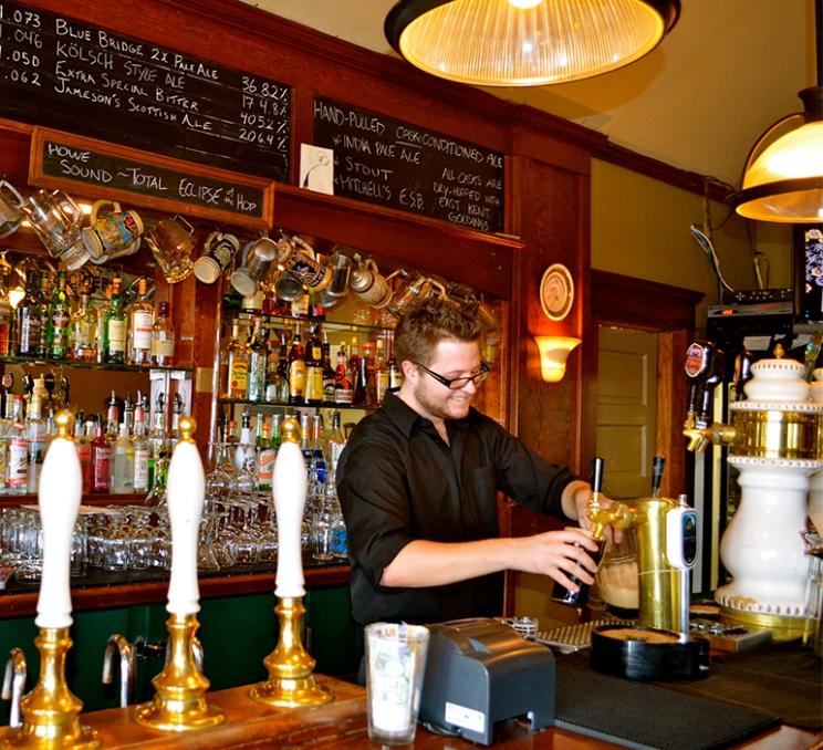 A bartender pours beer at Spinnakers Gastro Brewpub in Victoria, BC