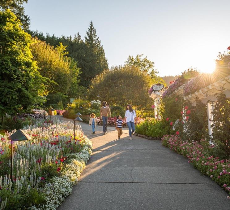 A young family walks down a pathway at The Butchart Gardens in Victoria, BC