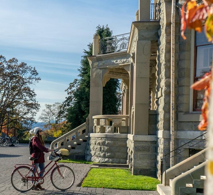 A woman takes a break on a cycling tour of the city at Craigdarroch Castle in Victoria, BC