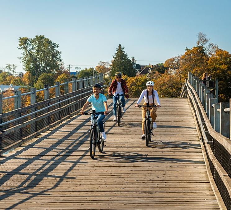 Three friends ride bikes along the Galloping Goose trail in Victoria, BC