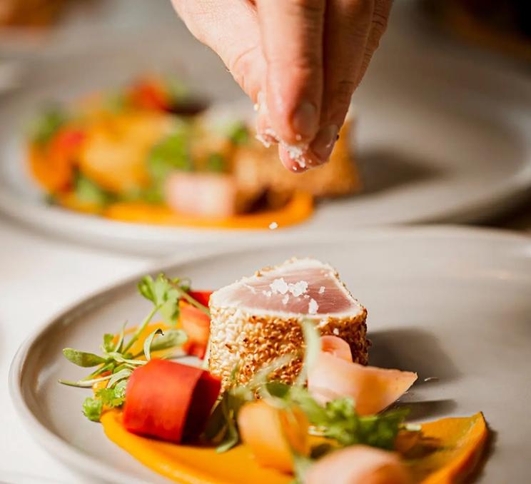 A chef adds the finishing touches to a dish at Ugly Duckling in Victoria, BC